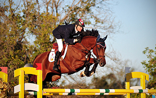 Ian Millar, athlète canadien en sports équestres, et son cheval sautent un obstacle durant une compétitio